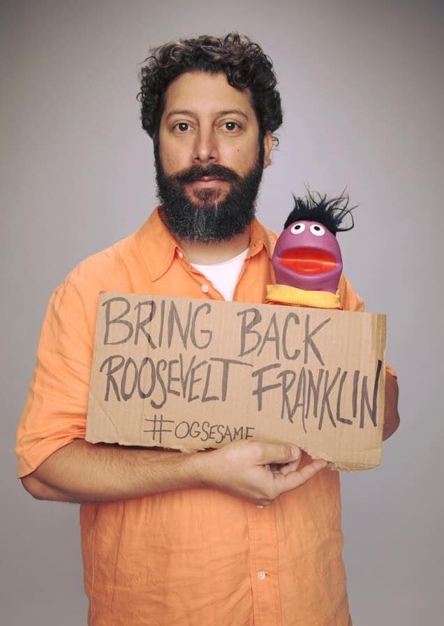 Bryan Sanders smiling beside a Roosevelt Franklin puppet