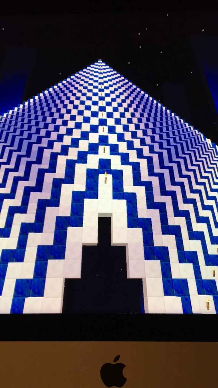 Generative blue and white checkerboard pyramid art on an iMac screen